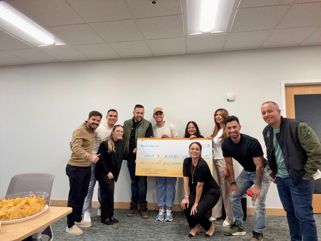 Participants celebrating with a ceremonial check at a Chelsea program session