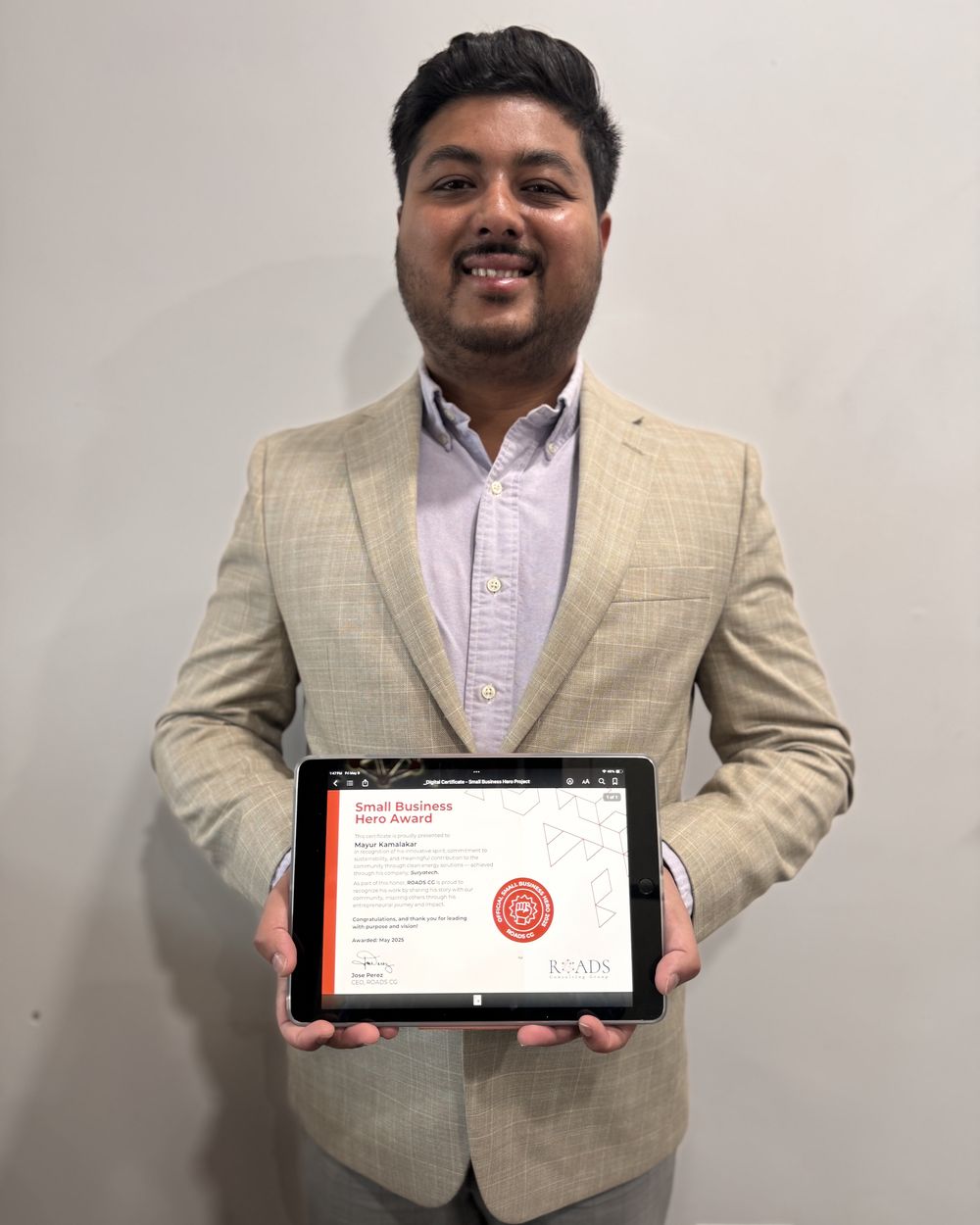 Mayur Kamalakar holding his Small Business Hero Award certificate